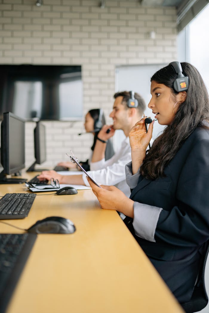 Focused call center agents handling customer queries in modern office.